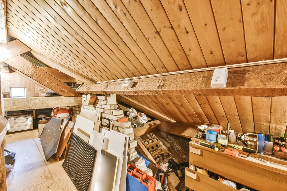 Vollgestellter Dachboden mit Holzbalken vor der Dachentrümpelung in Leipzig